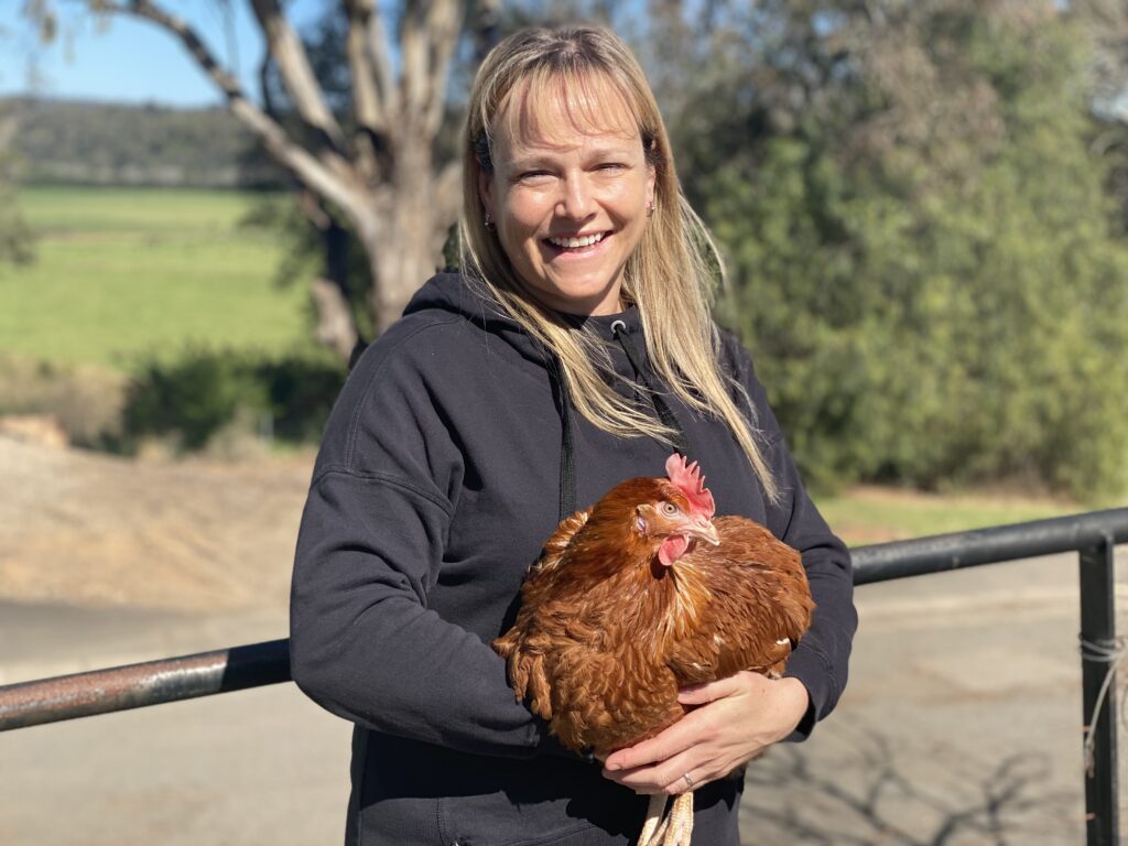 Christine Clark holding a chicken.