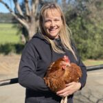 Christine Clark holding a chicken.