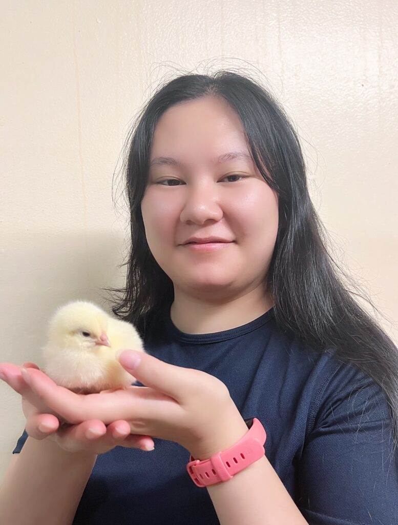 Portrait of Carria Xie holding a chick.